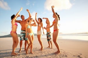 Group of teenagers dancing on the sea shore